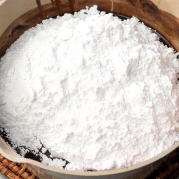 Adding powdered (icing) sugar gradually to he mixture.