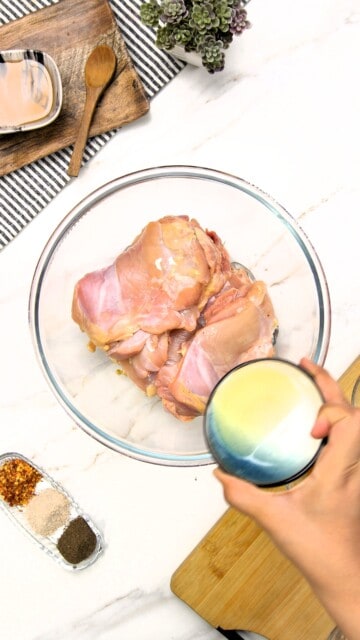 raw chicken thighs adding olive oil