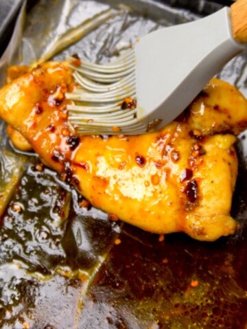 Brushing the chicken with the hot honey glaze