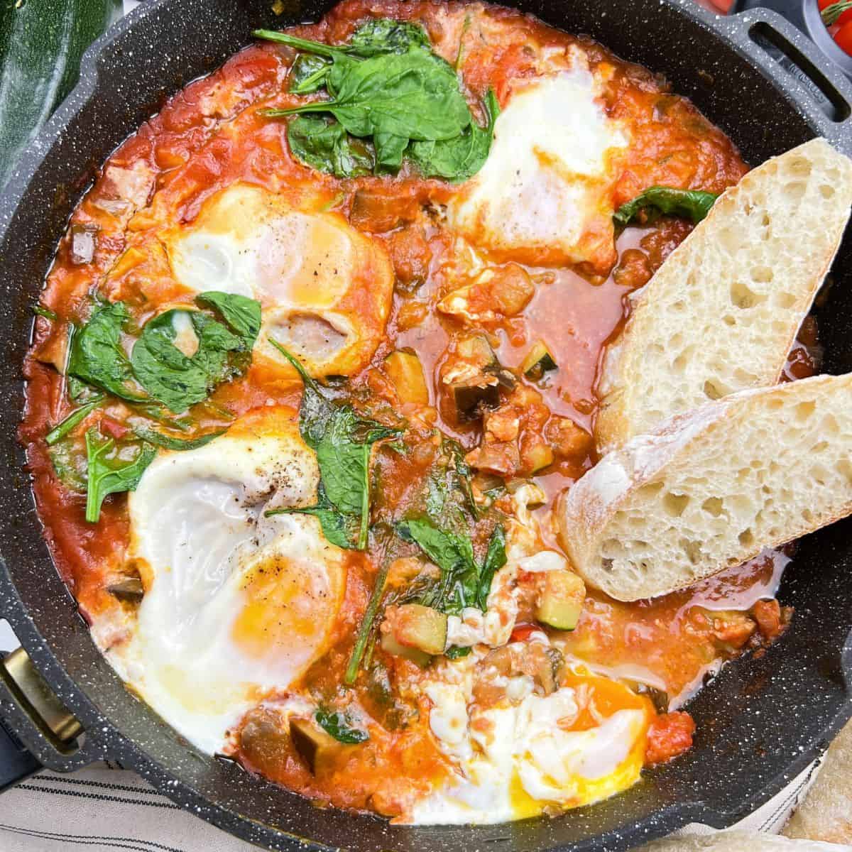 Mediterranean eggplant shakshuka with eggs in tomato sauce in skillet