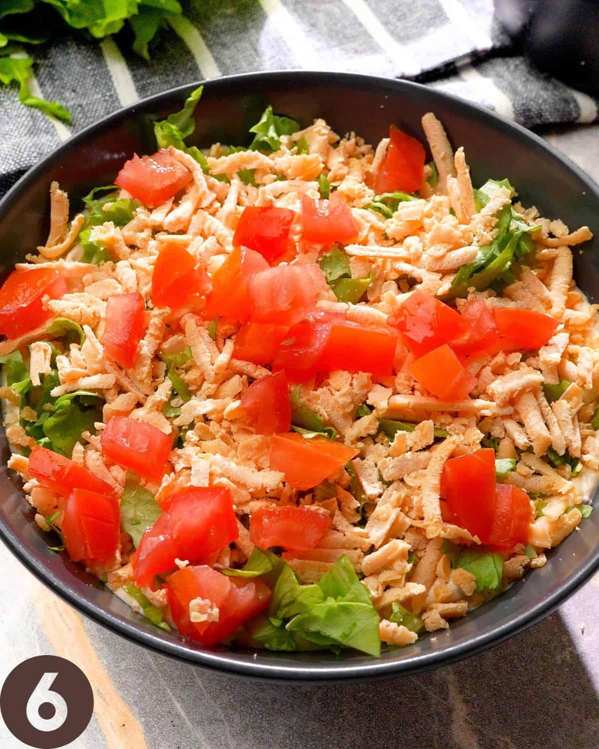 topping taco dip with diced tomatoes before serving.