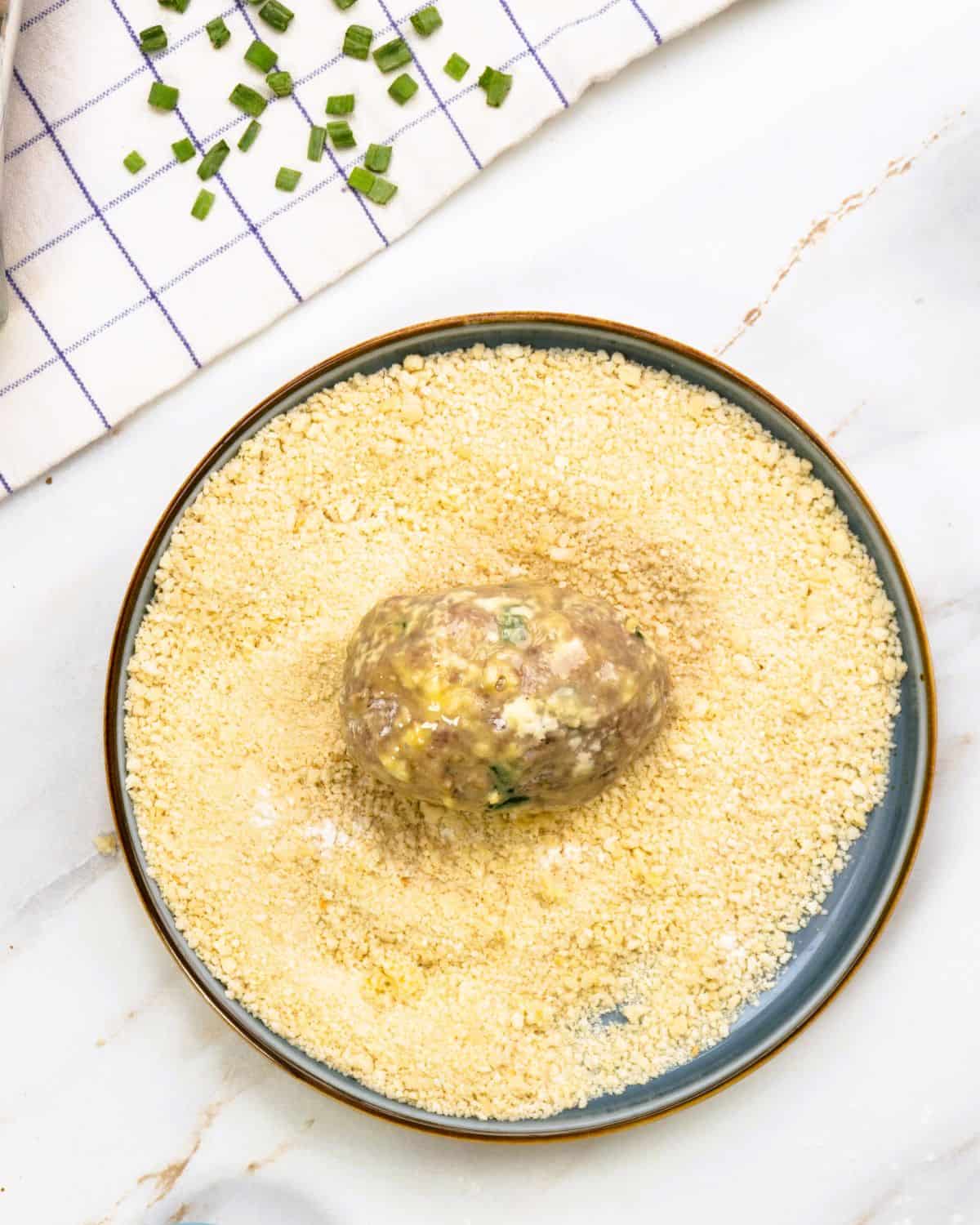Rolling the Scotch eggs in panko breadcrumbs.
