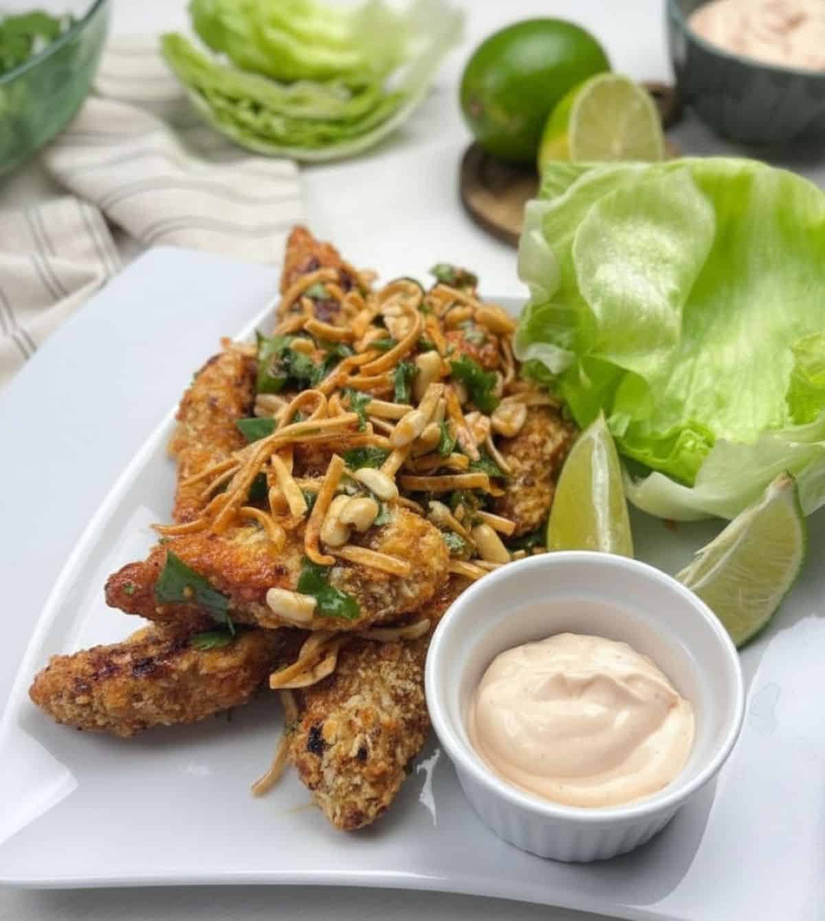 Szechuan chicken lettuce wraps with crispy chicken, spicy mayo, peanuts, and iceberg lettuce.