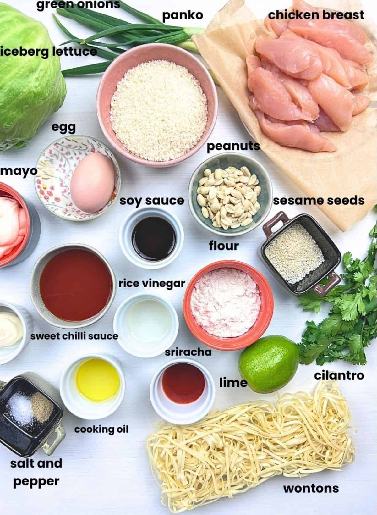Ingredients for szechuan chicken lettuce wraps including chicken, panko, lettuce, sweet chili sauce, peanuts, herbs, and spicy mayo ingredients.