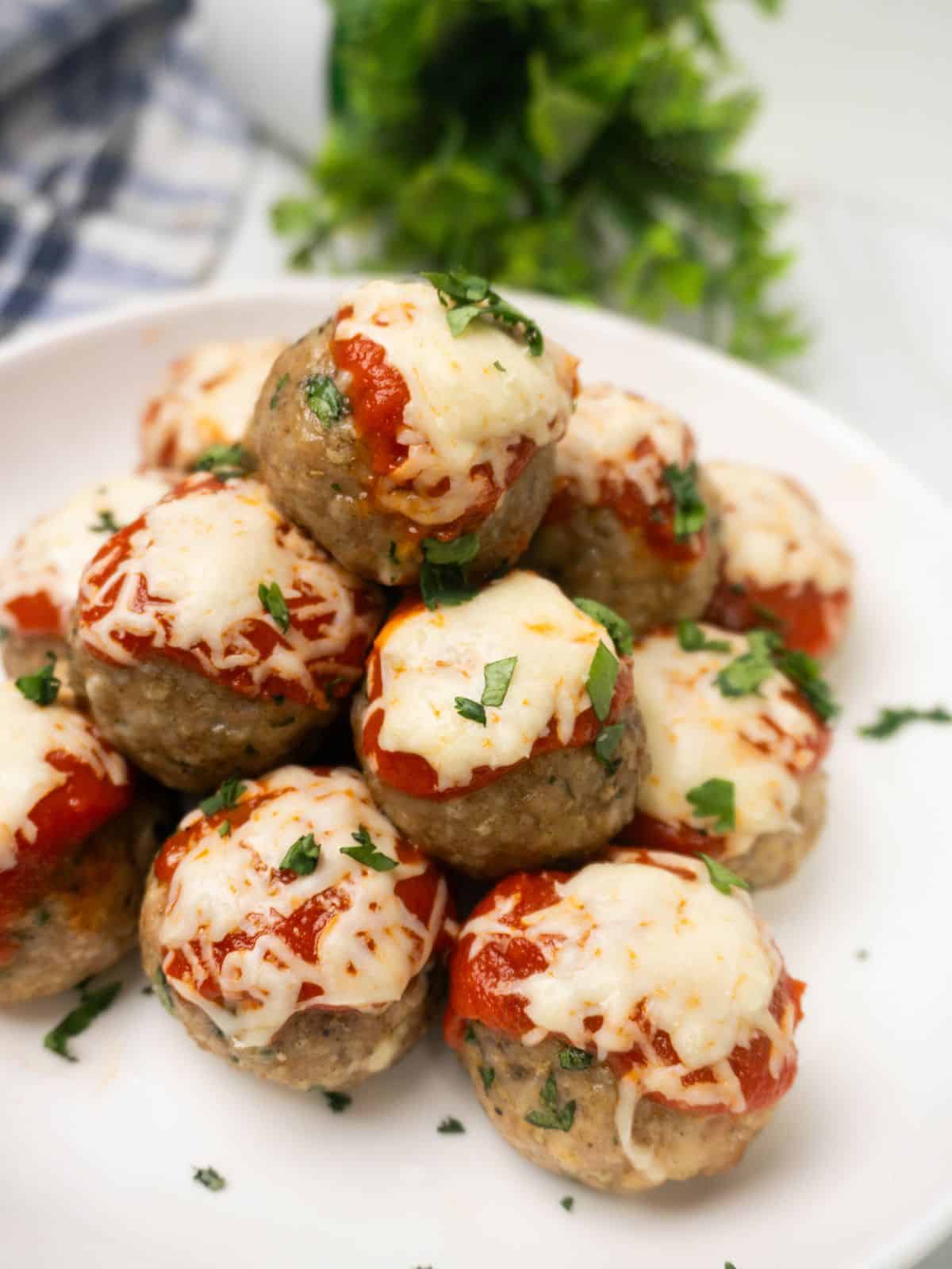 Baked Chicken Parmesan Meatballs served with marinara sauce and fresh parsley