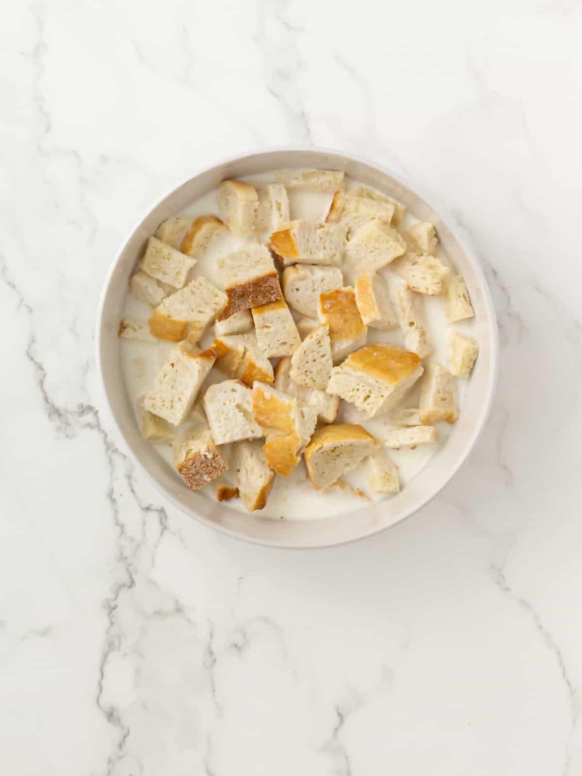 a bowl with bread soaked in warm milk.