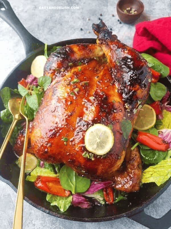 Whole roast chicken adobo with golden-brown skin and a glossy garlic, soy, and vinegar glaze, served for Christmas dinner.