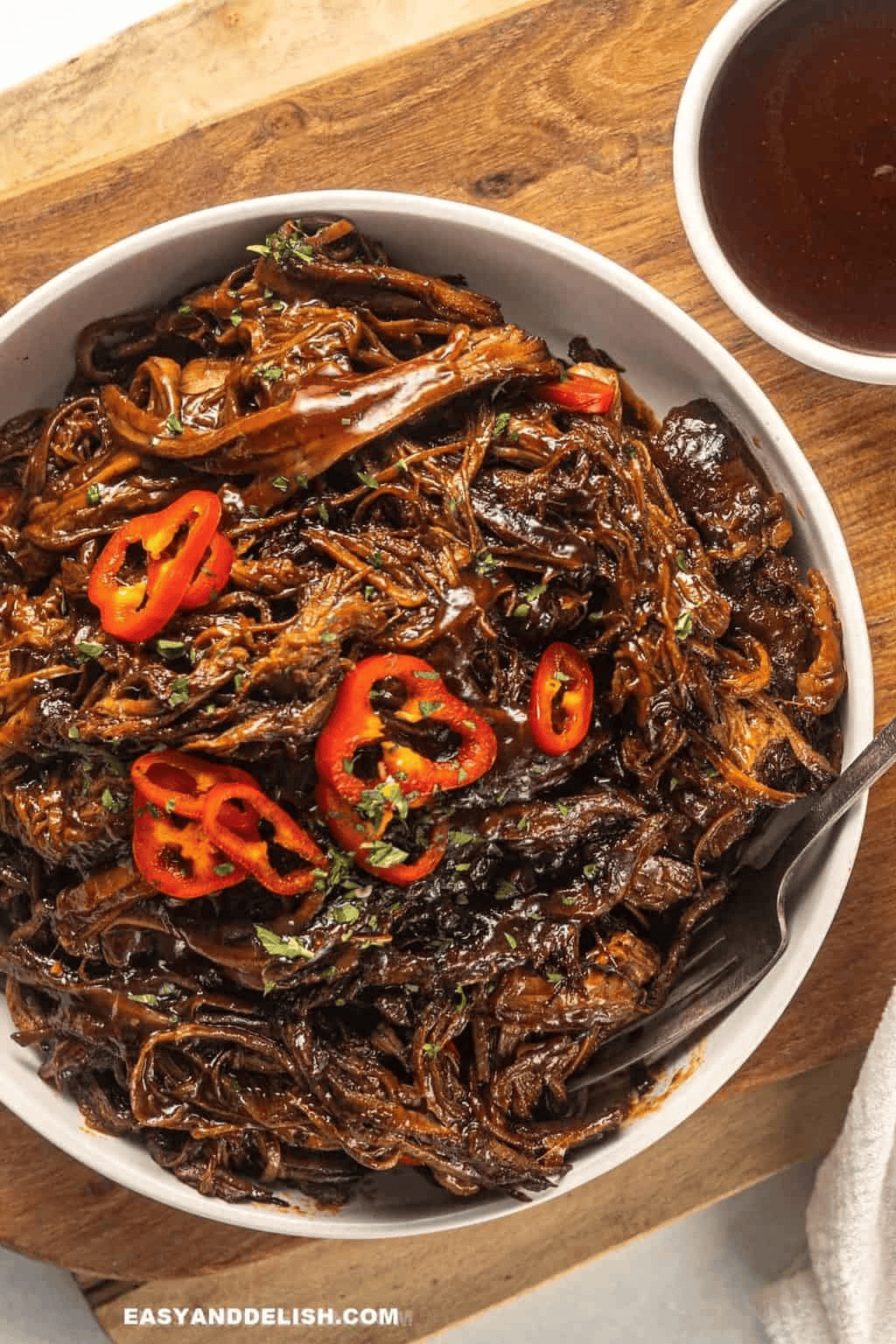 Tender shredded beef brisket coated in barbecue sauce, arranged on a serving platter for Christmas dinner.